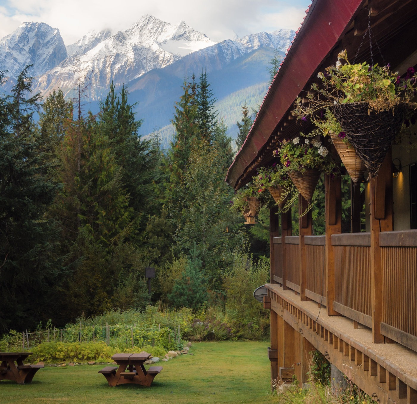 Side of the lodge with mountains in background and hanging flower pots